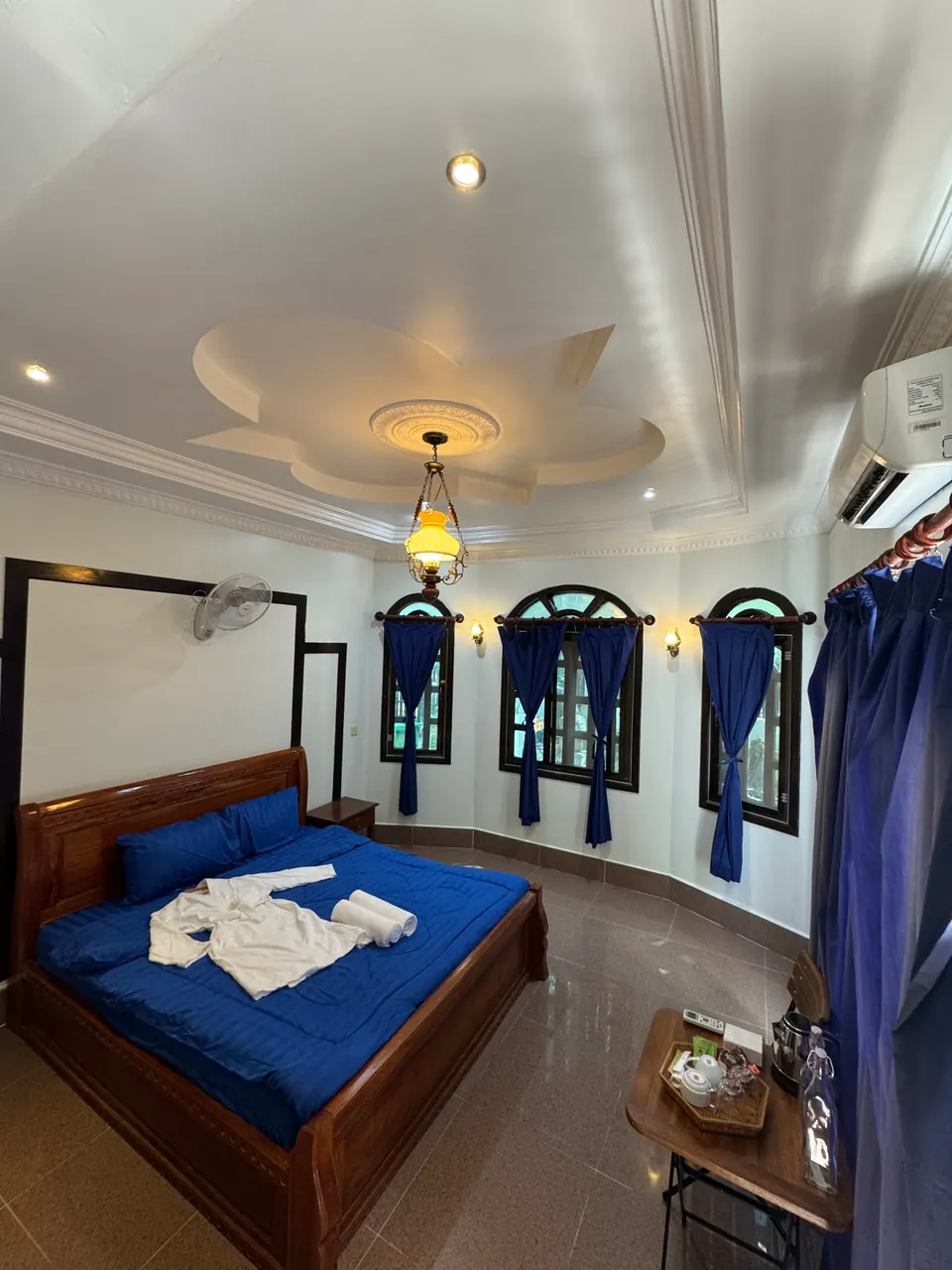 Double room with arched windows and blue curtains