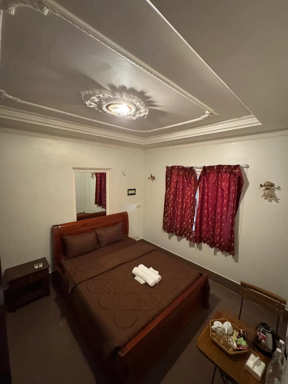 Double room with a king bed and red curtains