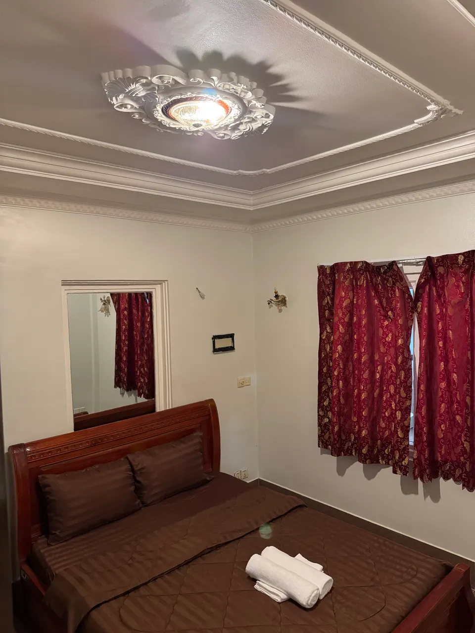 Double room with wooden bed and mirror